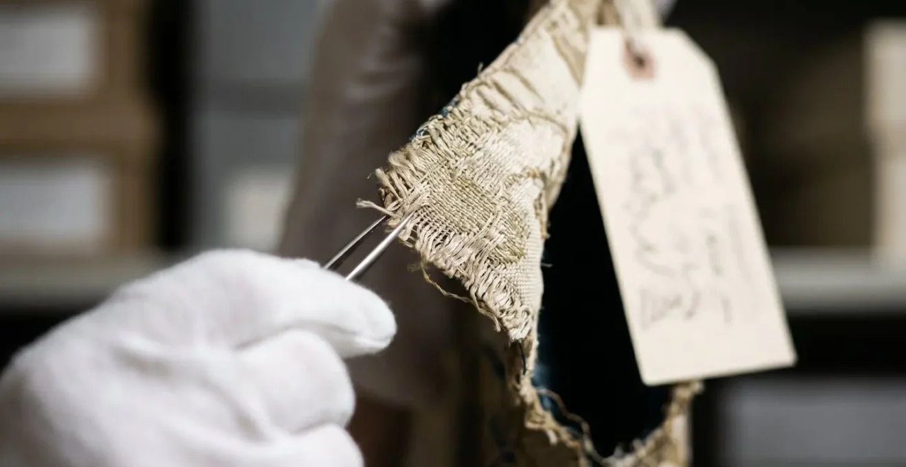 Extreme close-up of textile fibers and conservation tags on archived fashion piece
