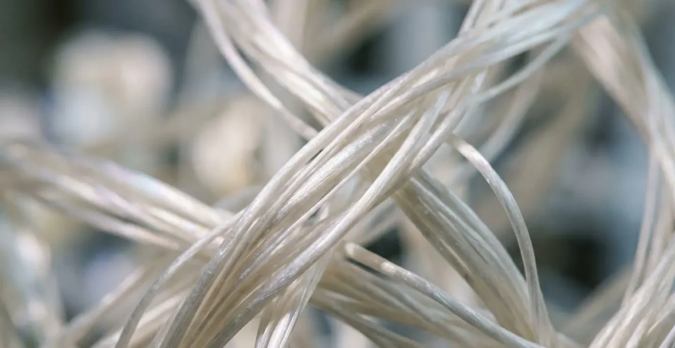 Extreme close-up of recycled ocean plastic fibers showing their transformed smooth texture
