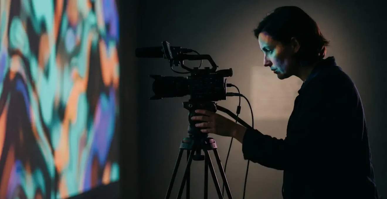 Wide shot of conservation studio with professional video equipment documenting generative art installation